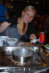 She's smiling now, but wait til she eats this spicy hot pot!
