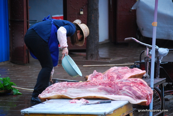 A butcher with a freshly sliced pig on display.