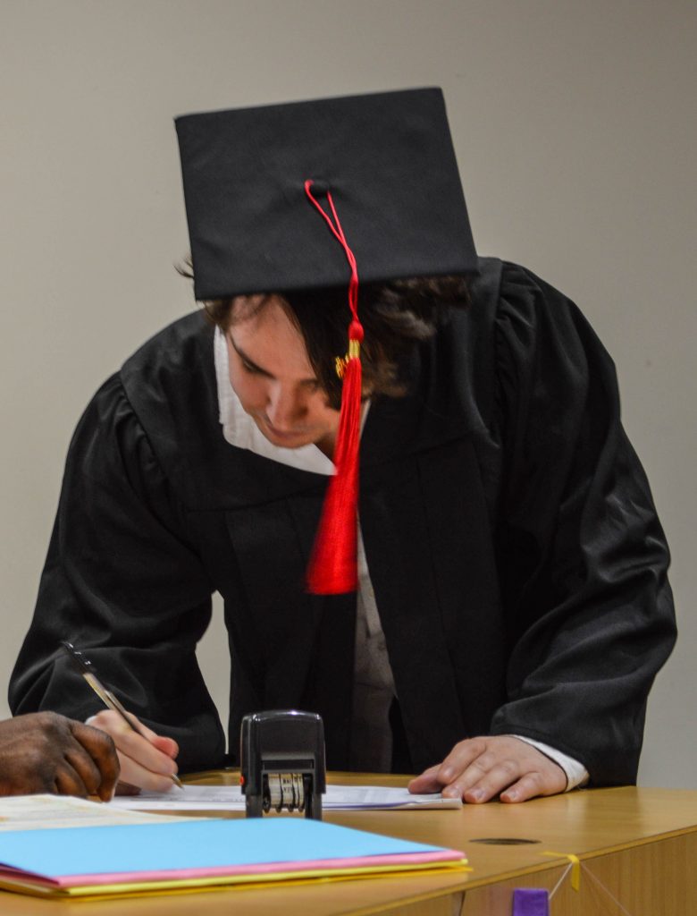 Me signing for my diploma.
