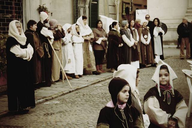 Children, women and beggars waiting for the arrival of St. Francis.