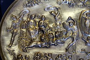 Cybele and Attis (seated right, with Phrygian cap and shepherd's crook) in a chariot drawn by four lions, surrounded by dancing Corybantes.