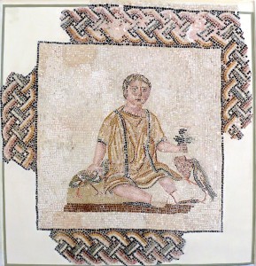 Mosaic from a Roman funerary monument, depicting a young boy sitting, with a fixed glaze; his right hand holds a partridge, his left a bunch of grapes with a thrush pecking at them. Beginning third century Sousse mausoleum. Courtesy of WikiCommons & Ad Meskens.
