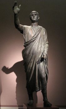 Aule Metele is a Romano-Etruscan work in the Roman style and depicts an Etruscan man wearing a short Roman toga and footwear. His right arm is raised to indicate that he is an orator addressing the public. Courtesy of Wikimedia Commons.
