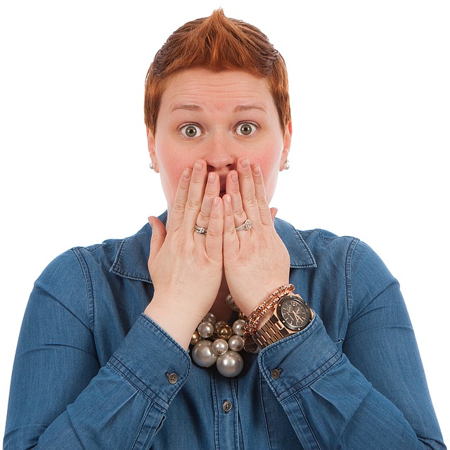 woman covering her mouth in shock