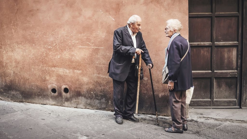 two elderly people talking in the street