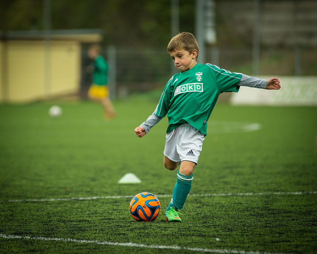 young child playing soccer