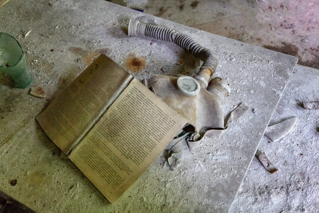book and gas mask under rubble