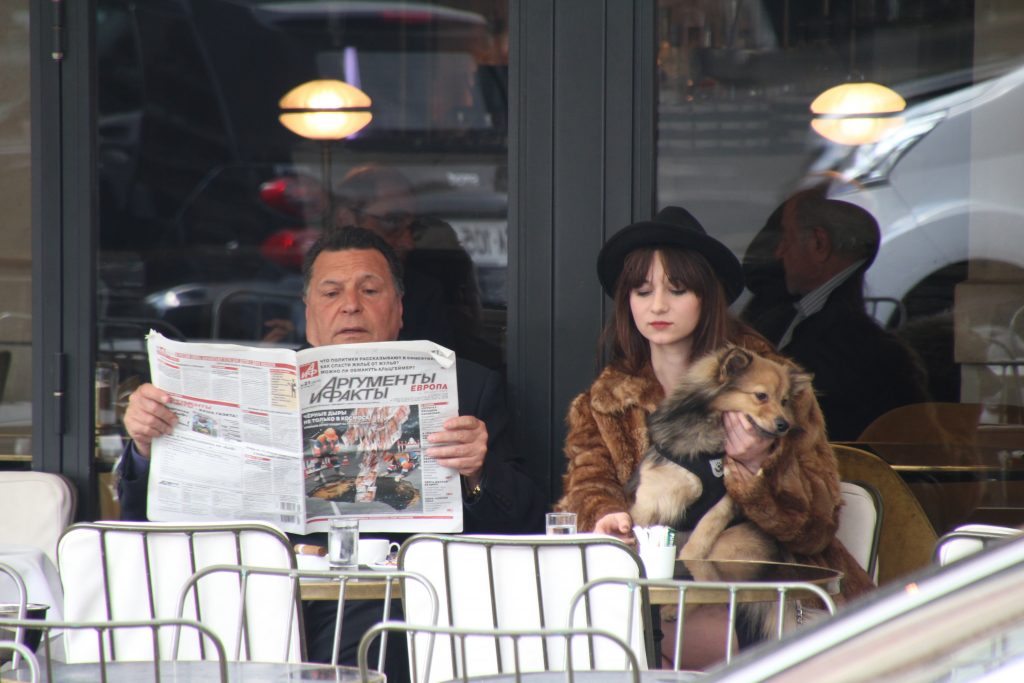 man reading a newspaper at a cafe
