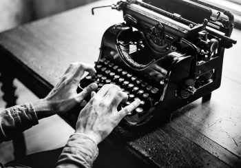 hands typing on a typewriter