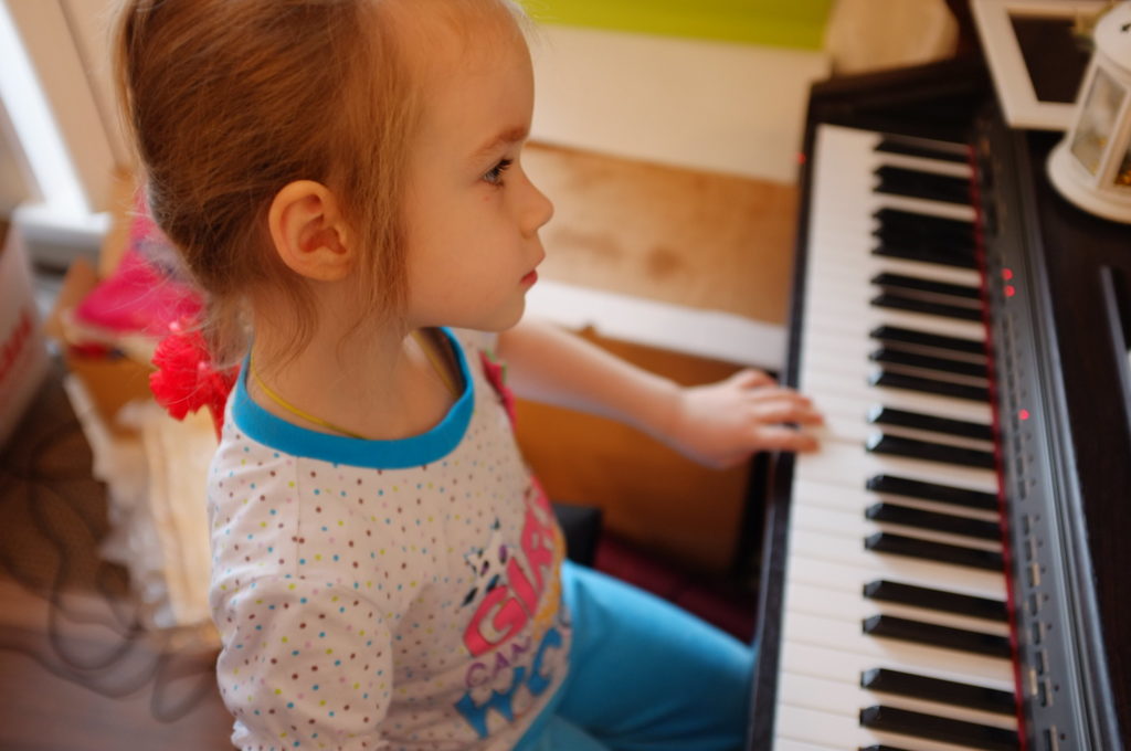Little girl is playing piano